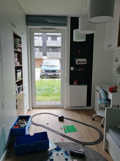 The child playroom with a window and a parked Mercedes Benz van on Bernata street, vertical
