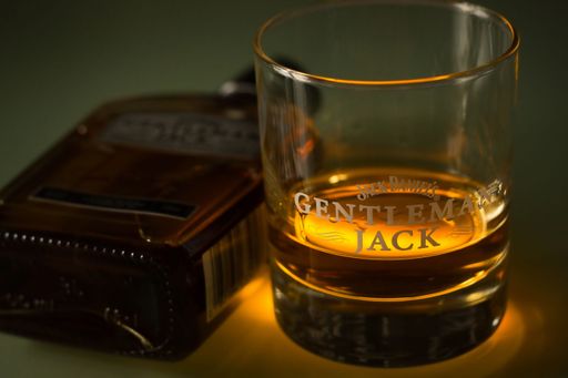 The high-angle view of a bottle of Gentleman Jack and a glass of whiskey