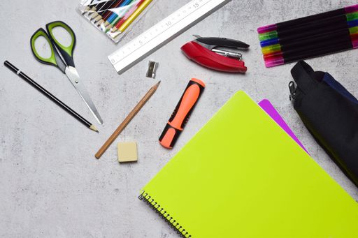 An assorted school supplies scattered on the blue background