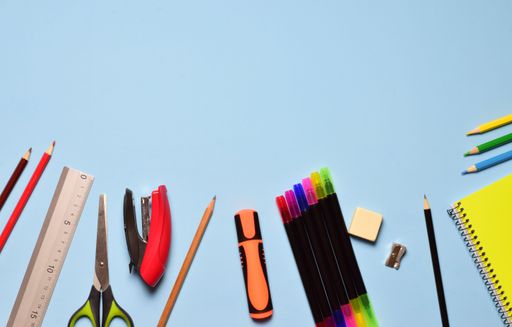 An assorted school supplies scattered on the blue background