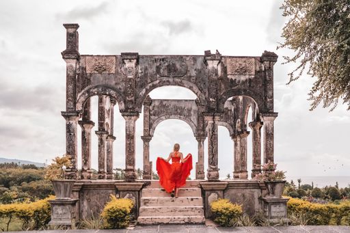 A girl in a red dress in the Water Palace Soekasada Taman Ujung Ruins, Bali Island