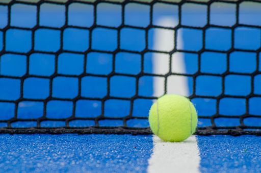 selective focus, ball on a blue paddle tennis court near the net