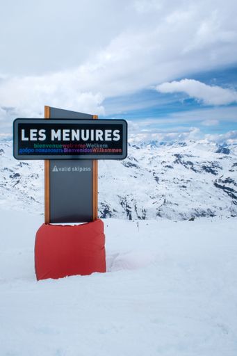 Les Menuires, France, April 5 2022, signpost to luxury town les menuires in skiing area Trois Valles, translation: three valleys, horizontal shot shot