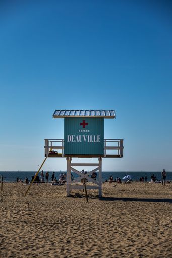 A vertical of a Lifeguard station in Deauville's sandy beach with people on vacation in France