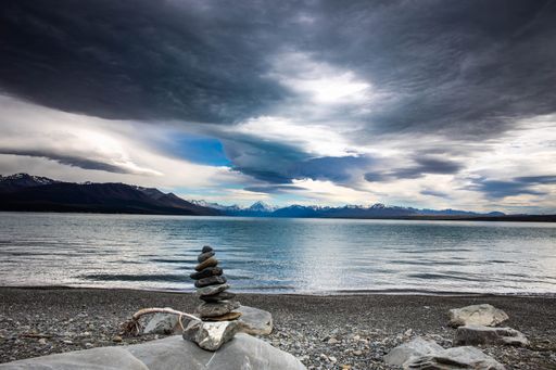 Beautiful panoramic view of a lake surrounded by mountains against a cloudy sky