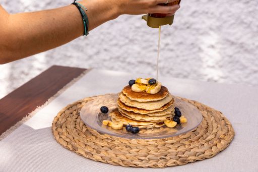 A pancake with berries and bananas on a table