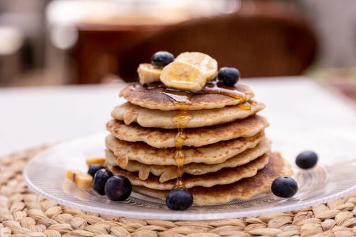 A pancake with berries and bananas on a table