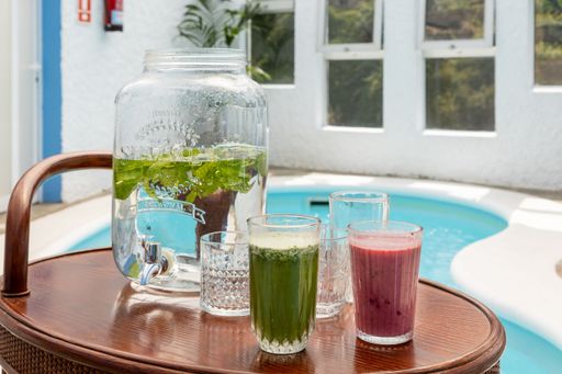 A closeup of fresh cocktails in a room with swimming pool