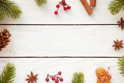 A top view of Christmas decorations and food on a wooden surface with copy space