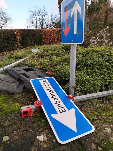 A vertical shot of one standing and one fallen sign on the street