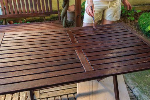 A person  brushing a varnish on a wooden table