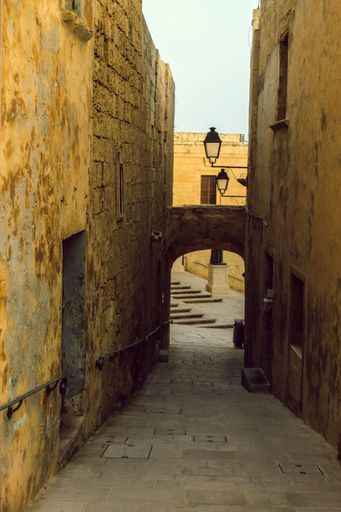 A vertical shot of a narrow vintage street at the Tales Of The Silent City Museum in Mdina, Malta