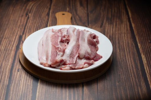 Thin slices of Korean Pork Belly with skin on a wooden board
