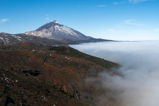 An aerial view of clouds floating over hills near Mount Teide in Tenerife Island, Spain