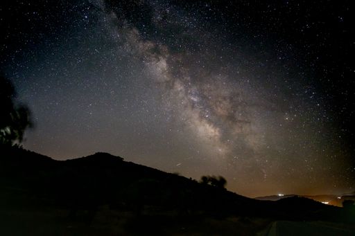 A magical view of the galaxy center known as Milky Way, sky covered with bright stars over mountain.
