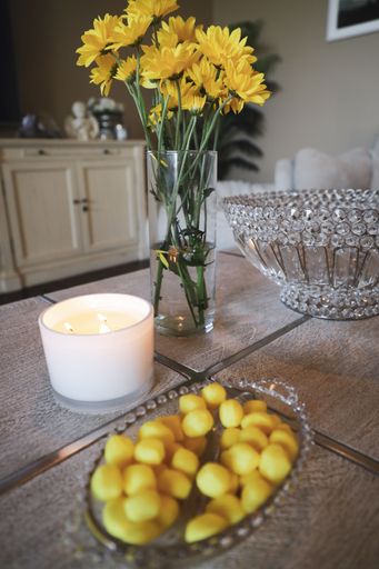 A vertical shot of yellow chrysanthemum flowers in a vase on a table