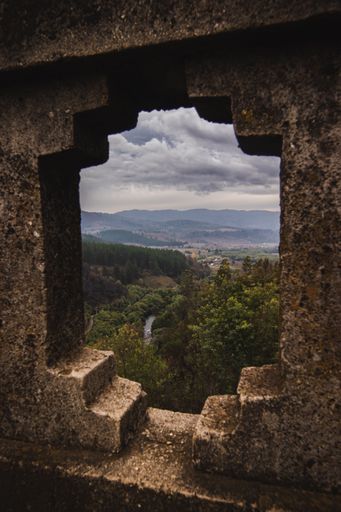 A vertical shot of the view of the landscape through a bridge