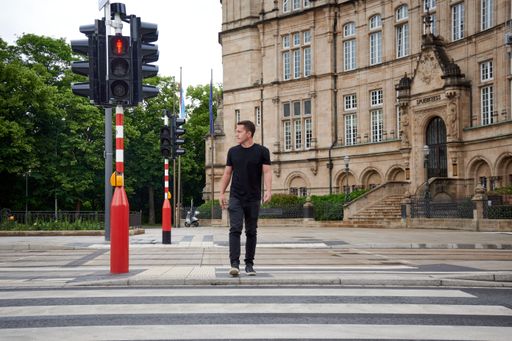 A man crossing a street in front of State Savings Bank, Luxembourg