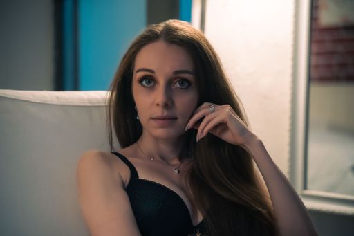 A young and sexy Caucasian girl in black underwear sitting on armchair