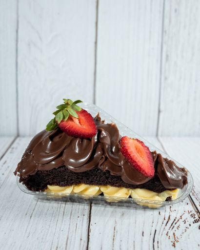 A vertical shot of a piece of delicious cake with a chocolate and strawberry topping in a plastic container