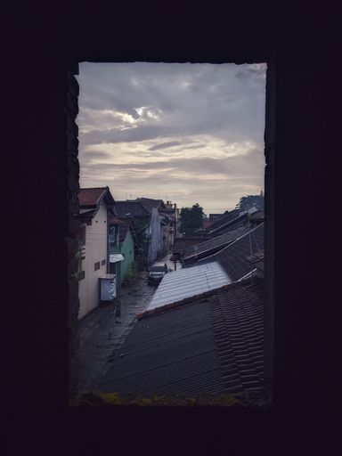 the view of the cloudy sky after the rain seen from the window frame