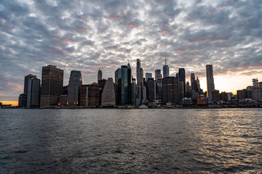 The mesmerizing skyline of New York City displaying its skyscrapers under a cloudy sky at sunset