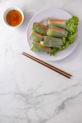 An overhead shot of Vietnamese spring rolls, fish sauce dip and chopsticks with space for your text