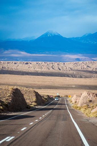 A vertical shot of cars on asphalt turning road in the Atacama Desert in Chile