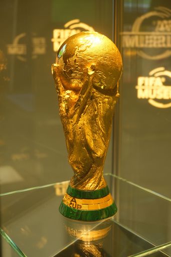 A vertical shot of the Fifa World Cup trophy displayed to the crowd in Zurich, Switzerland