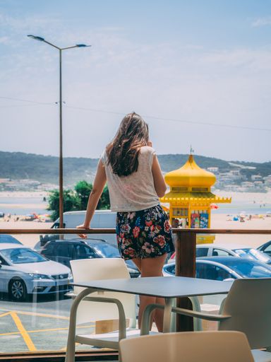 A vertical shot of girl's silhouette in Foz do Arelho beach background, in Portugal