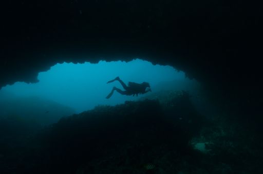 An underwater shot of a SCUBA diver exploring an underwater cave