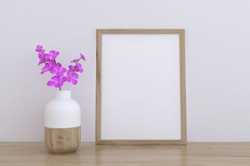 A 3D rendering of a mockup frame and a flower vase near a white wall