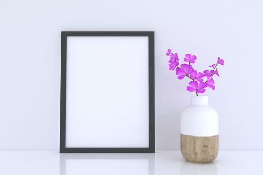 A 3D rendering of a mockup frame and a flower vase near a white wall