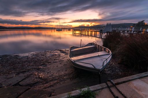 An empty boat on the shore at sunset. Brisbane Water, New South Wales, Australia.