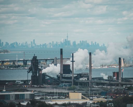 The smoke coming out from Hamilton factories with the Skyway bridge and Toronto skyline in the background