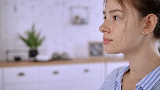 A closeup shot of the side profile of a young female with freckles and a pretty nose