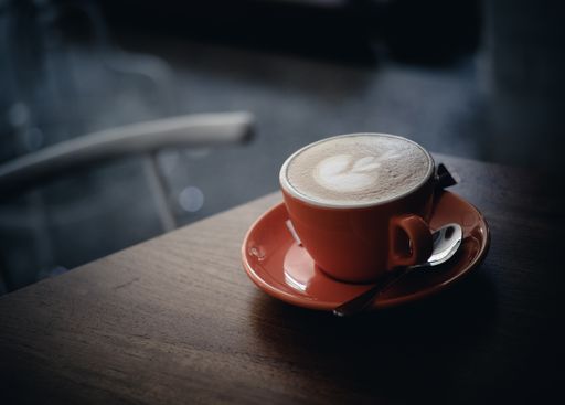 A closeup shot of a cup of coffee on a wooden table