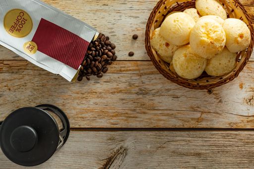 top view brazilian cheese bread, or 'pao de queijo' with coffe beans, french press over wooden table