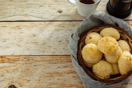 many cheese breads or 'pao de queijo' in basket and french press coffee maker, with fabric around