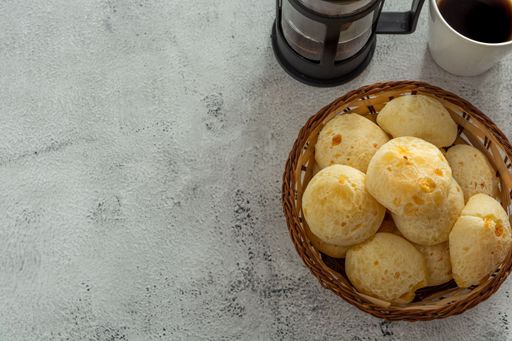 basket with cheese breads, or 'pao de queijo, with coffee itens, on stone table