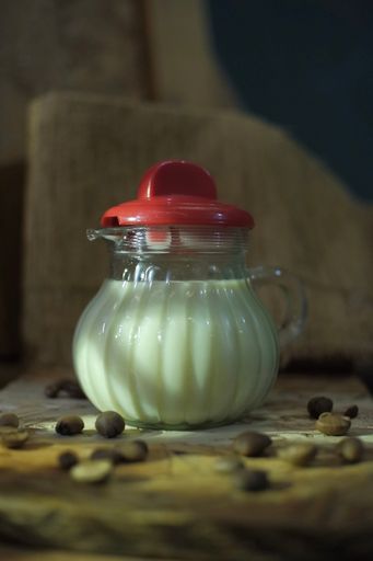 A vertical closeup shot of a container full of milk