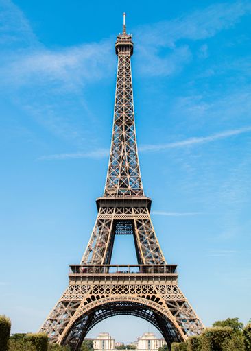 A vertical shot of the Eiffel Tower against the background of the blue sky. Paris, France.