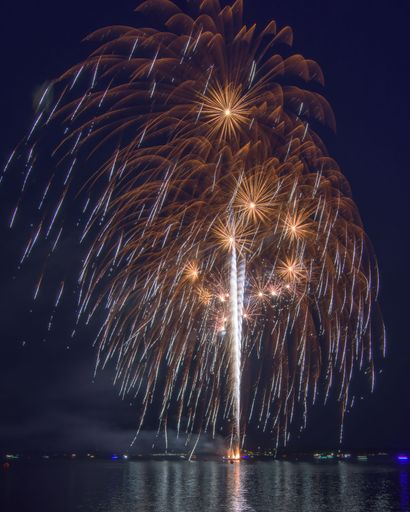 A vertical shot of fireworks in the night sky. Canada Day celebration.