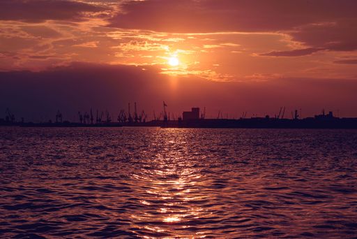 The beautiful golden sunset over the Aegean sea at Thessaloniki city with crane silhouettes in the background