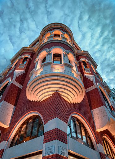 A low angle of the Logos Mansion with mystique lights in Thessaloniki against a cloudy sky