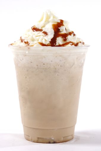 A vertical shot of iced cappuccino with whipped cream and caramel topping