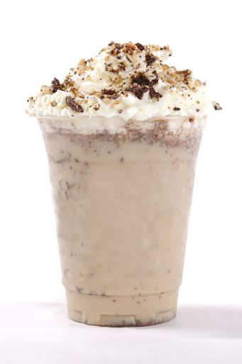 A close up shot of delicious creamy chocolate cold milkshake with whipped cream on top