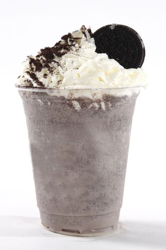 A close up shot of delicious chocolate cookie milkshake with whipped cream on top