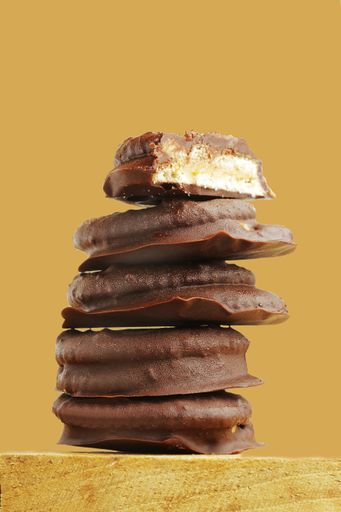 A close up shot of delicious chocolate cookies on top of each other in a yellow background