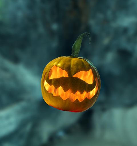 A Halloween pumpkin with flame inside on abstract blurred background